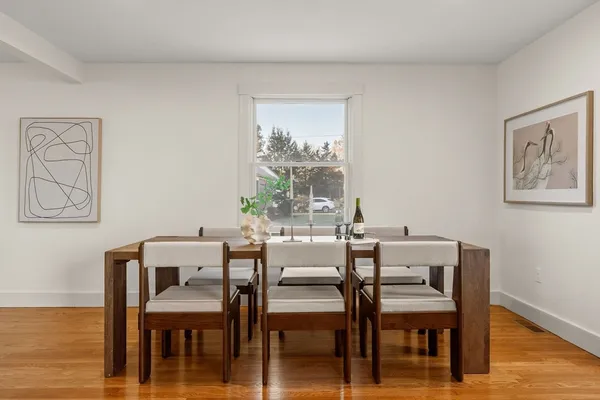 a dining room with furniture window and wooden floor