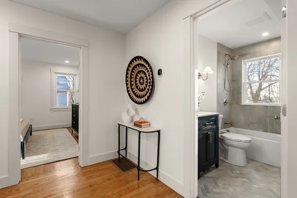 a view of a bathroom with mirror window and wooden floor