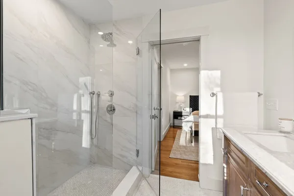 a bathroom with a granite countertop sink mirror and shower