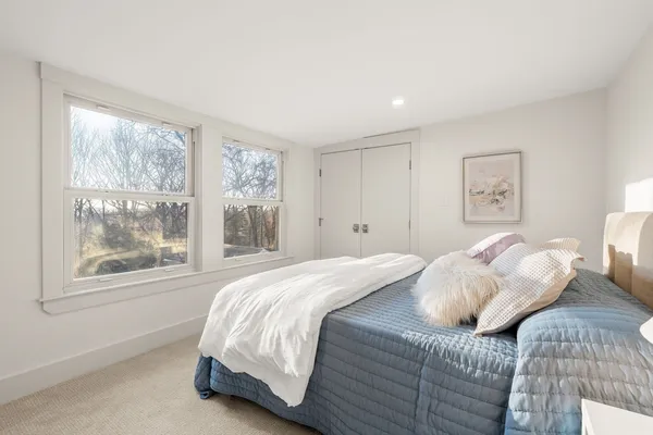 a bedroom with a bed and a large window