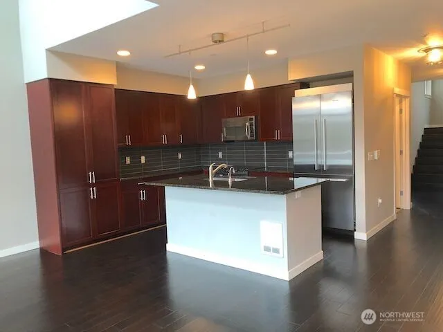 a kitchen with granite countertop a sink a stove and cabinets