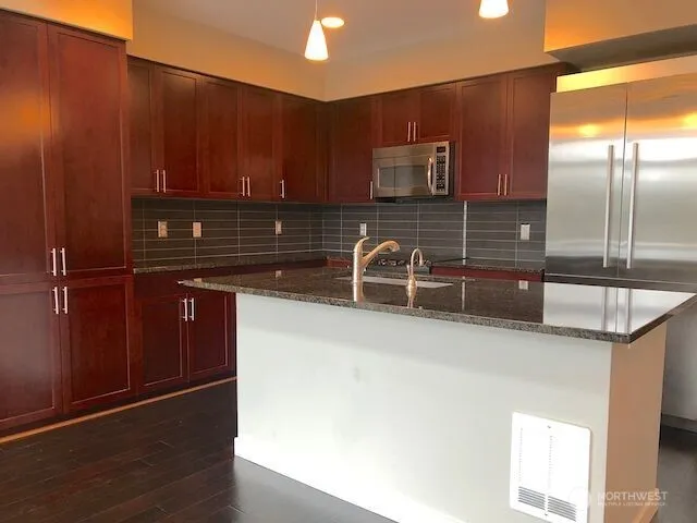 a kitchen with kitchen island a sink appliances and cabinets