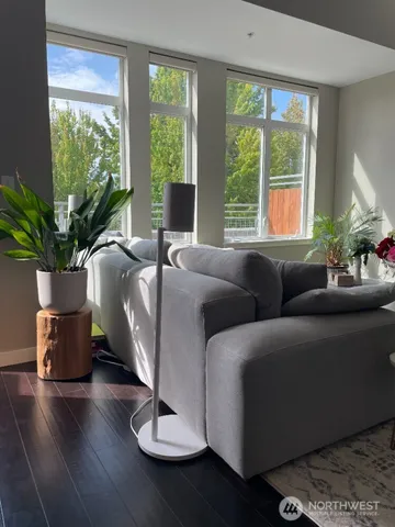 a living room with furniture wooden floor and a floor to ceiling window