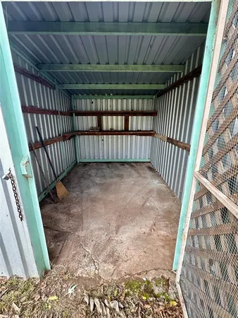 a view of backyard with wooden fence and a large tree