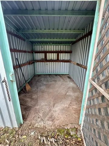 a view of backyard with wooden fence and a large tree