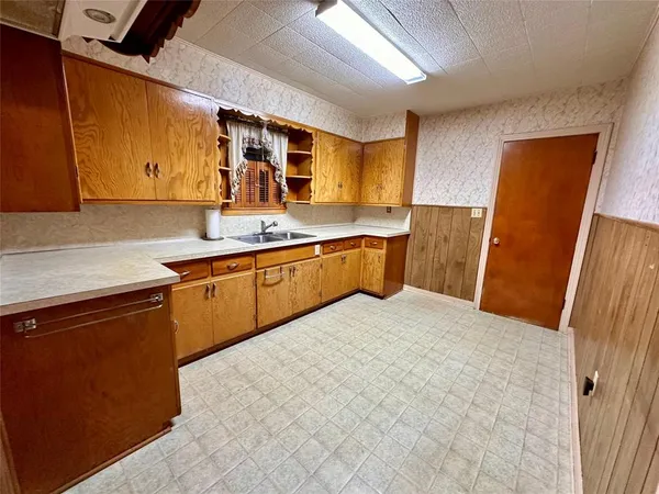 a kitchen with stainless steel appliances a sink a stove a refrigerator cabinets and a counter top space