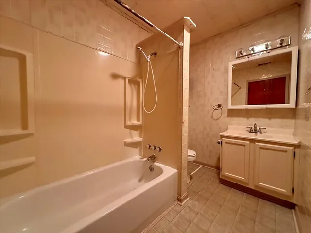 a bathroom with a granite countertop sink a toilet and shower