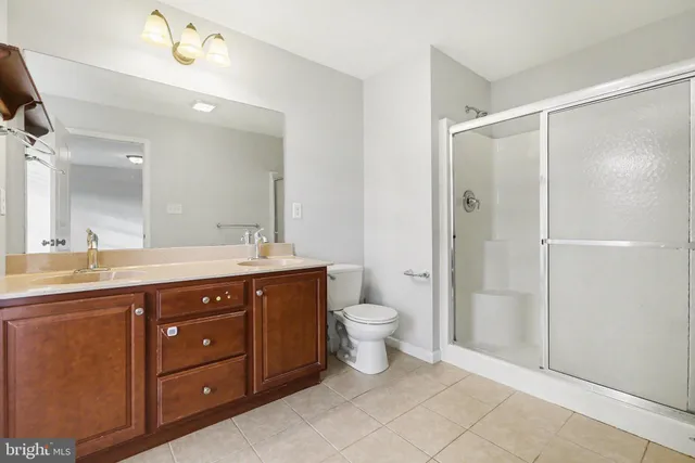 a bathroom with a double vanity sink toilet and shower