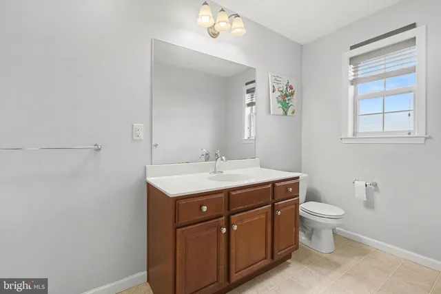 a bathroom with a toilet a sink a vanity and mirror