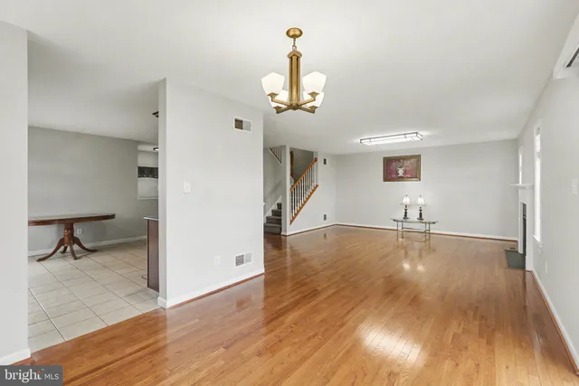 a view of a livingroom with wooden floor and a ceiling fan