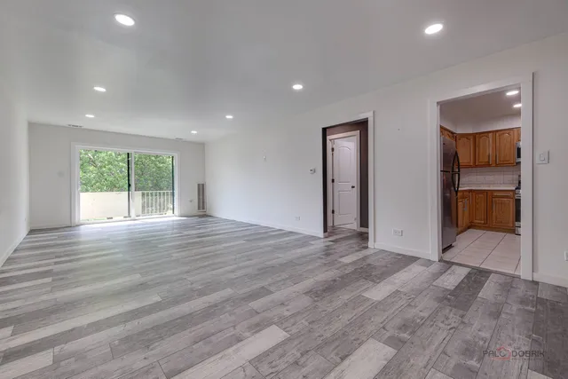 an empty room with wooden floor and a fireplace