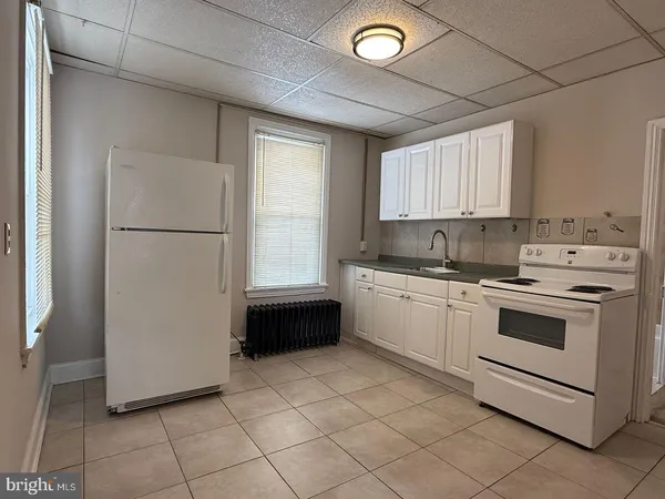 a kitchen with a refrigerator sink and cabinets