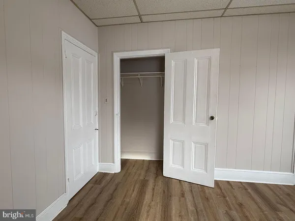 a view of empty room with wooden floor