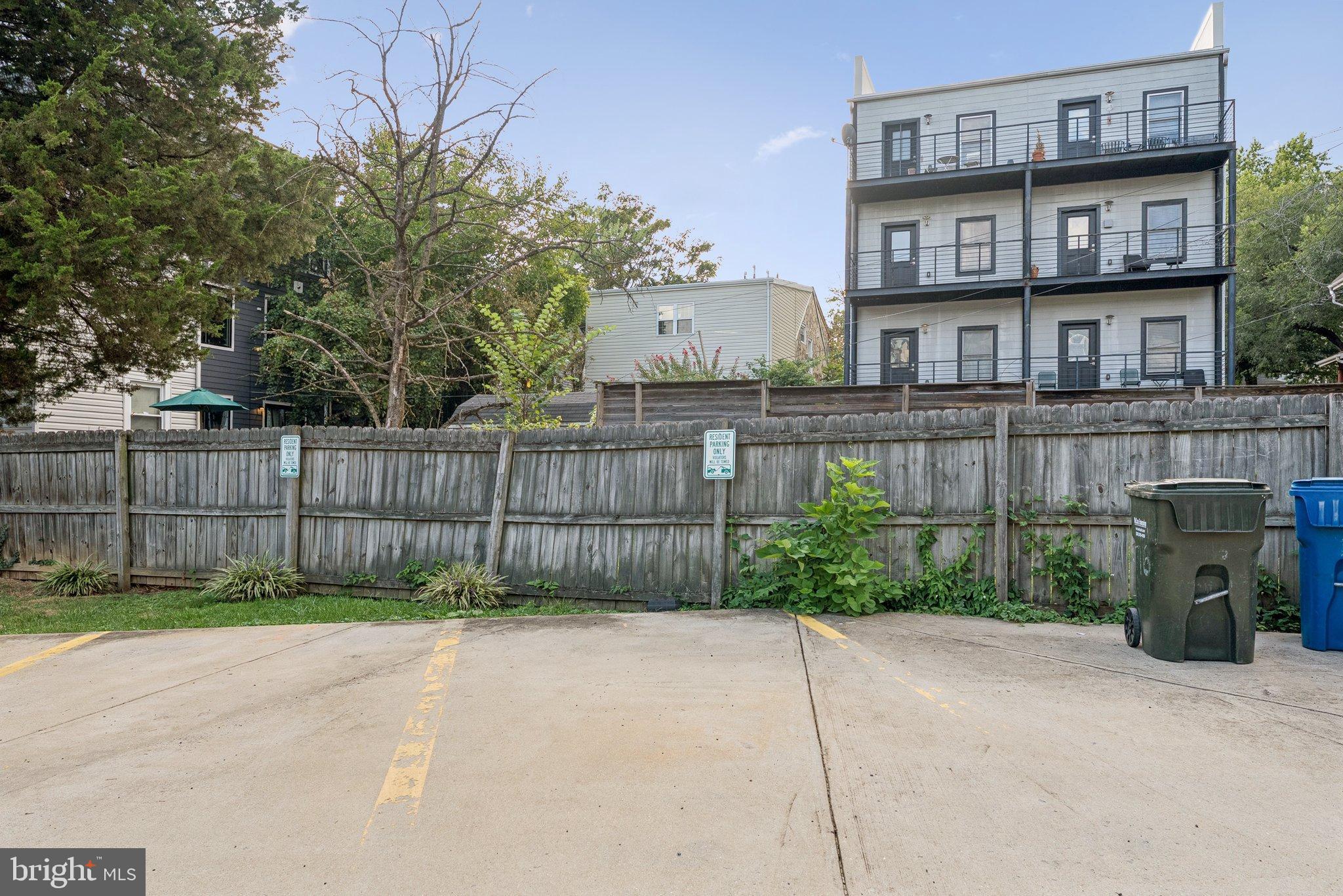 718 Jackson Street Northeast, Unit 1 Washington, DC 20017 - Photo 22 of 24 a view of a brick house with a small yard and a large trees
