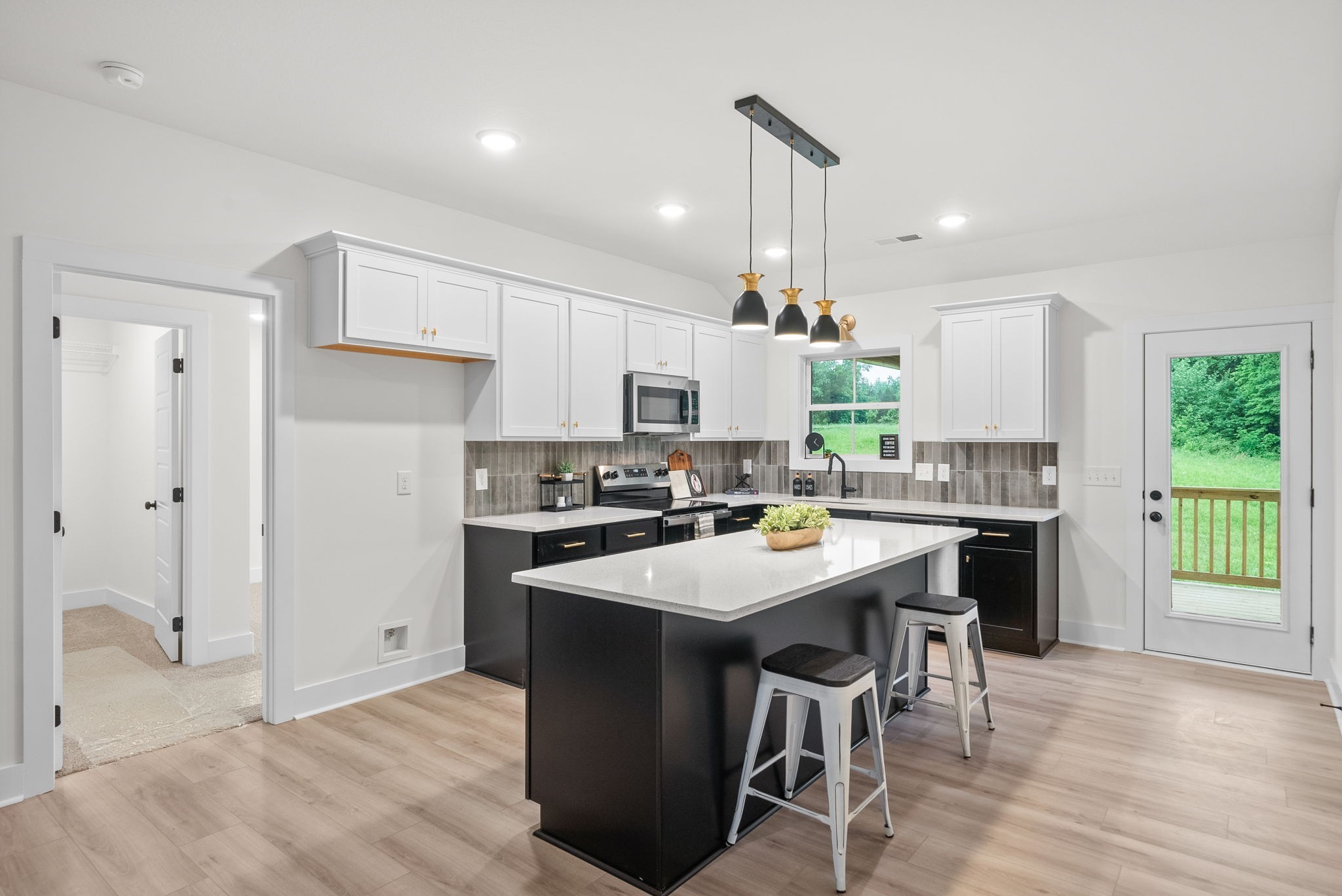201 Dewberry Road Clarksville, TN 37042 - Photo 14 of 56 a kitchen with a sink a stove a refrigerator and white cabinets with wooden floor