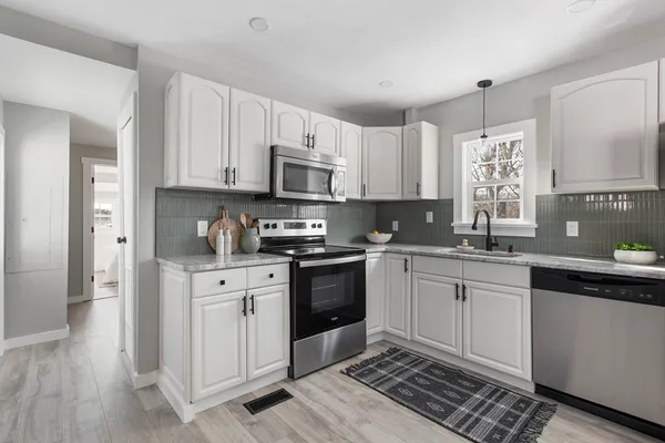 a kitchen with stainless steel appliances granite countertop a stove a sink and a refrigerator