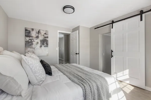 a bedroom with a bed and a painting on the wall