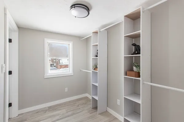 a view of an empty room with closet and wooden floor