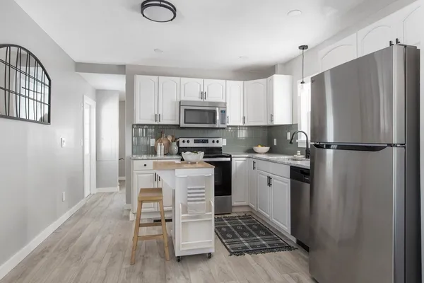 a kitchen with white cabinets and stainless steel appliances