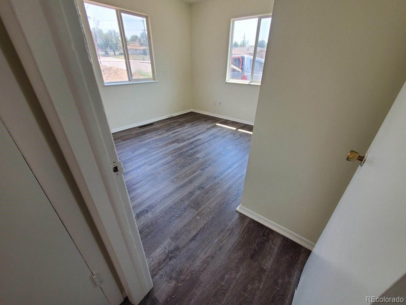 1720 Hampton South, Unit 3 Colorado Springs, CO 80906 - Photo 11 of 19 an empty room with wooden floor and windows