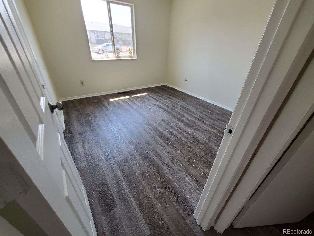 1720 Hampton South, Unit 3 Colorado Springs, CO 80906 - Photo 12 of 19 a view of an empty room with wooden floor and a window