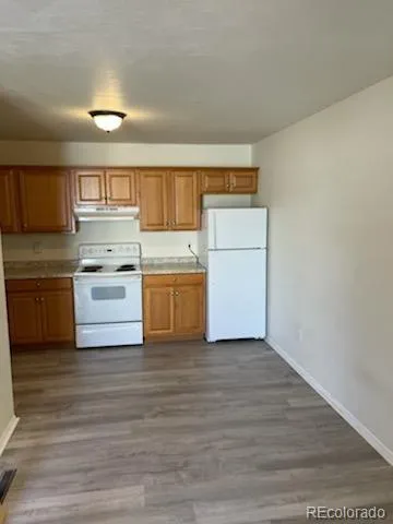 a kitchen with wooden cabinets and white appliances