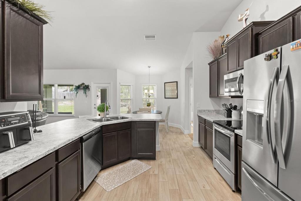 11042 Heth Court Weeki Wachee, FL 34613 - Photo 15 of 43 a kitchen with granite countertop a sink stainless steel appliances and cabinets