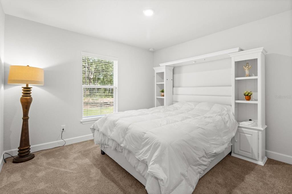 11042 Heth Court Weeki Wachee, FL 34613 - Photo 21 of 43 a large bed sitting in a bedroom next to a window