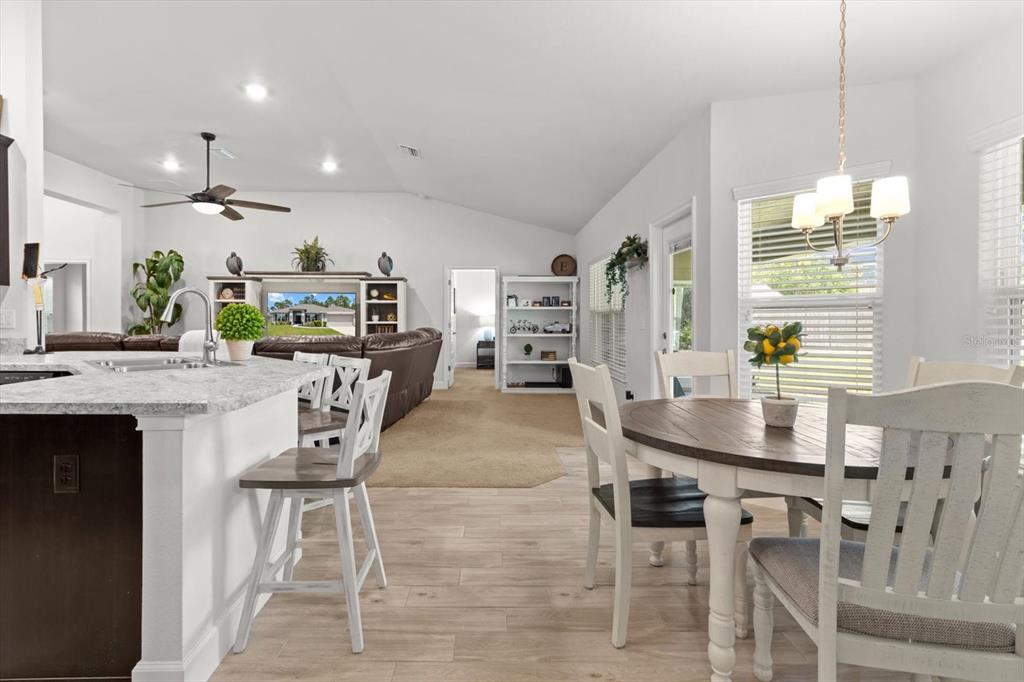 11042 Heth Court Weeki Wachee, FL 34613 - Photo 23 of 43 a kitchen with stainless steel appliances kitchen island granite countertop a table chairs and a refrigerator
