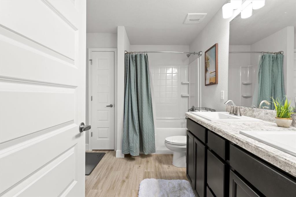 11042 Heth Court Weeki Wachee, FL 34613 - Photo 24 of 43 a bathroom with a granite countertop sink toilet a large mirror a vanity and shower