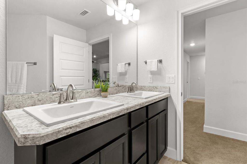 11042 Heth Court Weeki Wachee, FL 34613 - Photo 25 of 43 a bathroom with a granite countertop sink a large mirror and a shower