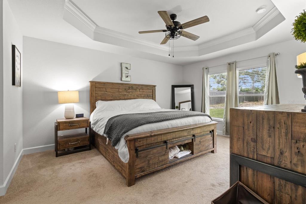 11042 Heth Court Weeki Wachee, FL 34613 - Photo 26 of 43 a bedroom with a bed a ceiling fan and a dresser