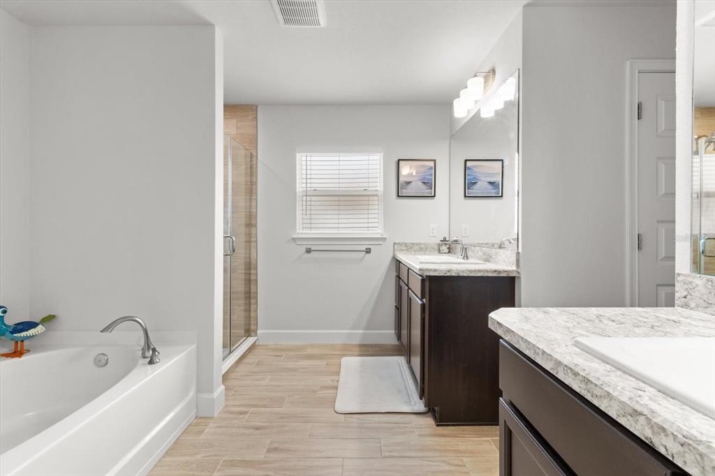 11042 Heth Court Weeki Wachee, FL 34613 - Photo 29 of 43 a bathroom with a granite countertop sink and a bathtub