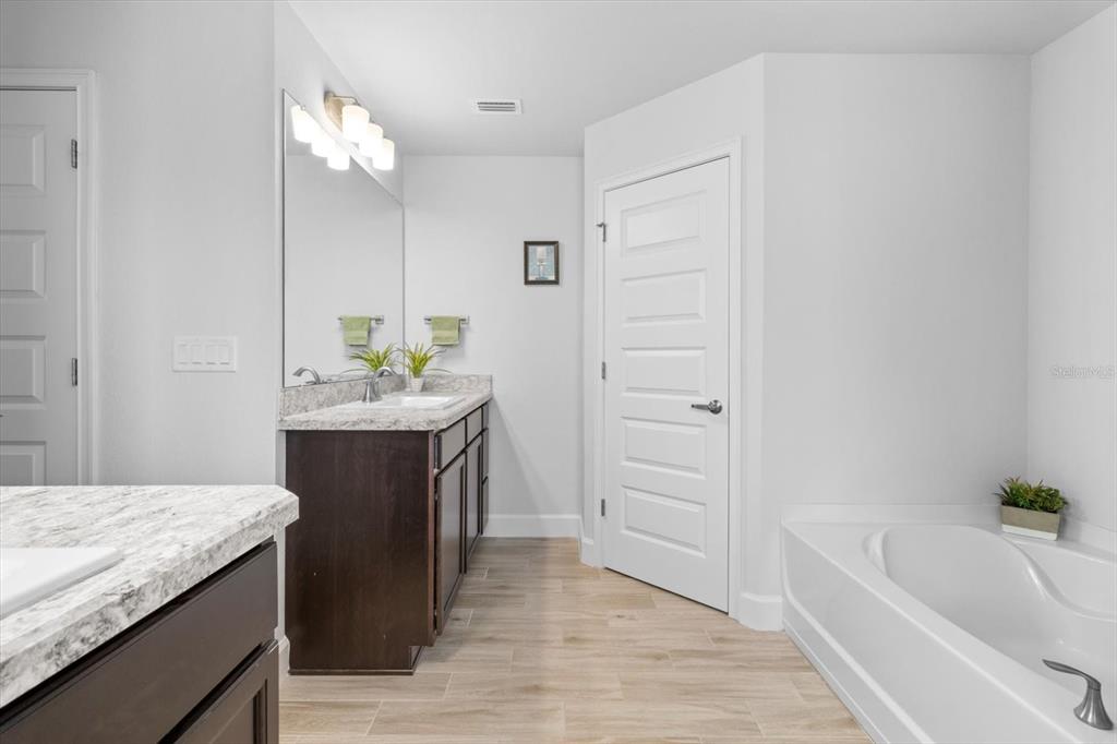 11042 Heth Court Weeki Wachee, FL 34613 - Photo 30 of 43 a spacious bathroom with a granite countertop sink a toilet a mirror and bathtub