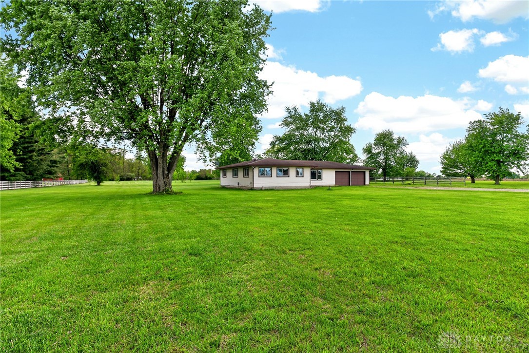 1005 Free Road New Carlisle, OH 45344 - Photo 32 of 43 Expansive green lawn and mature trees frame this charming residence with ample outdoor space.