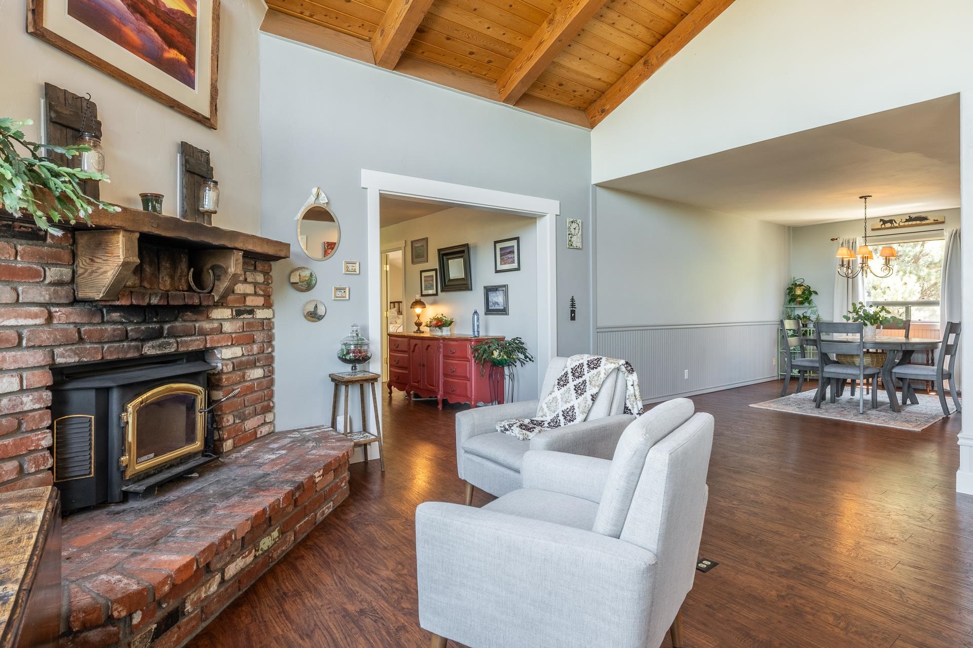 537 Aspen Spring Ranch Road Mammoth Lakes, CA 93546 - Photo 8 of 40 Exposed beam ceiling with wood paneling, brick fireplace with wood-burning insert, wood-finish flooring, and light gray wall paint