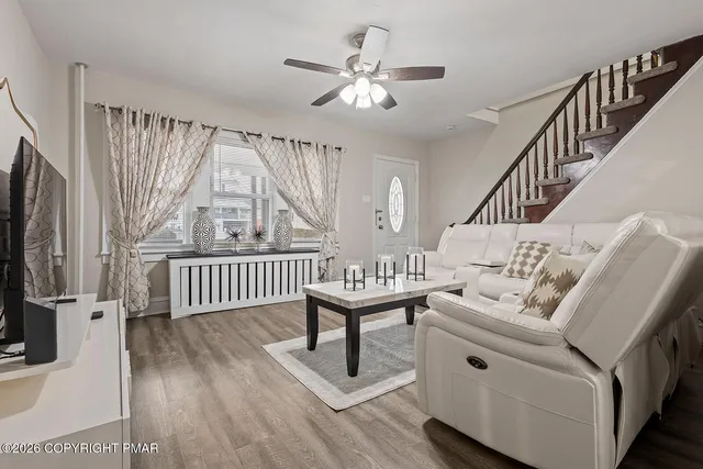 a living room with furniture a large window and a flat screen tv