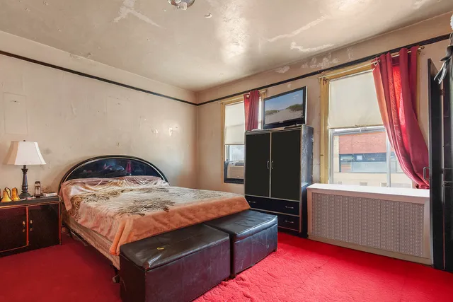 a bedroom with furniture and a large window