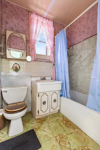 a bedroom with a bed and a dresser next to a window