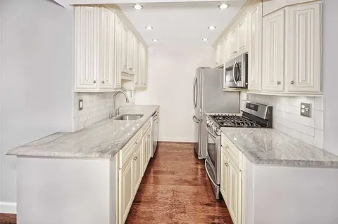 a kitchen with granite countertop a sink stove and cabinets