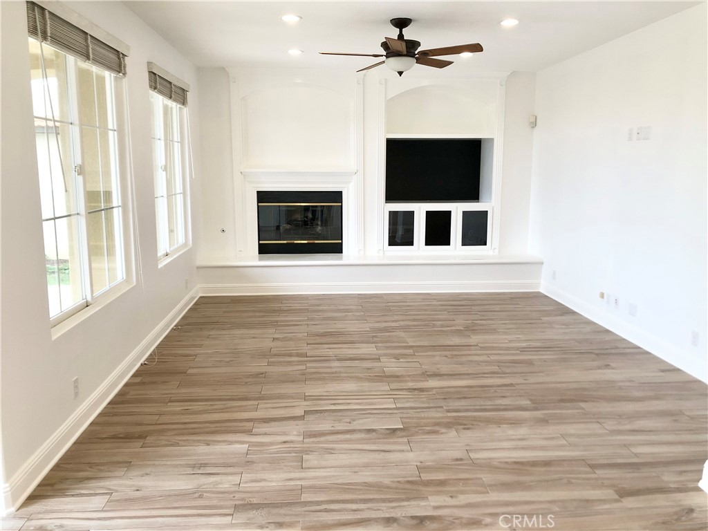 24 Tesoro Newport Coast, CA 92657 - Photo 8 of 19 a view of a livingroom with a fireplace a ceiling fan and windows