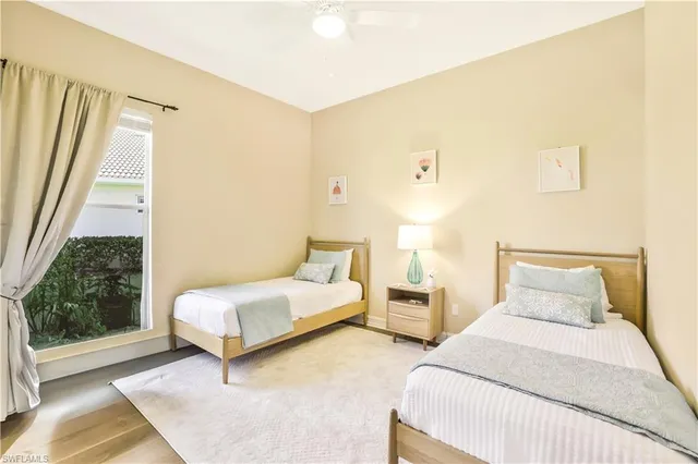 a bedroom with two beds and large window