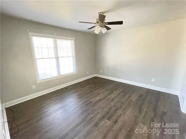 a view of a room with wooden floor and a window