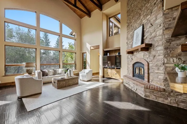 a living room with fireplace furniture and a floor to ceiling window