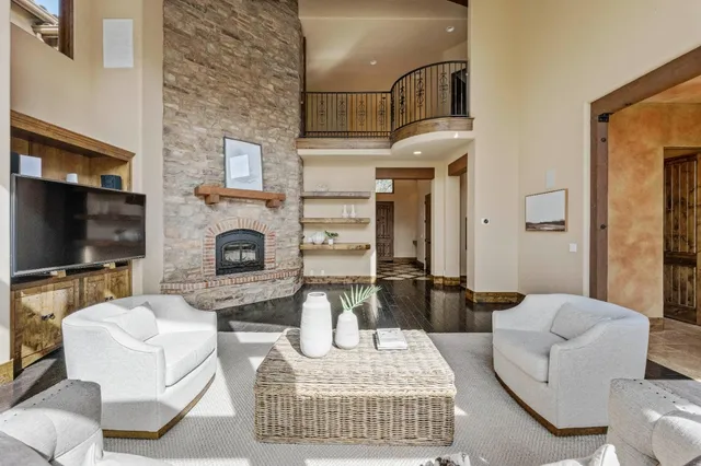 a living room with furniture a large window and wooden floor