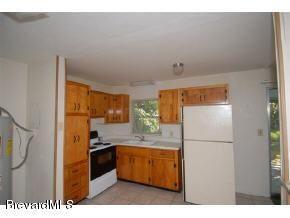 304 3rd Street Merritt Island, FL 32953 - Photo 4 of 6 a kitchen with a refrigerator and a sink
