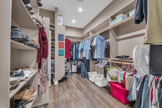 a view of walk in closet with clothes and shoes