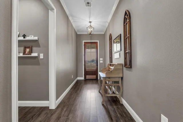 a view of a hallway with wooden floor and a bathroom