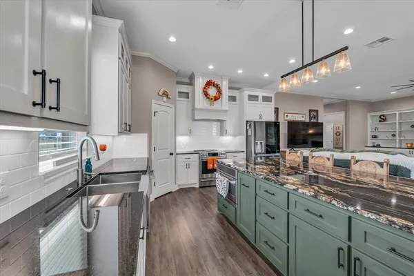a kitchen with stainless steel appliances granite countertop a sink stove and cabinets