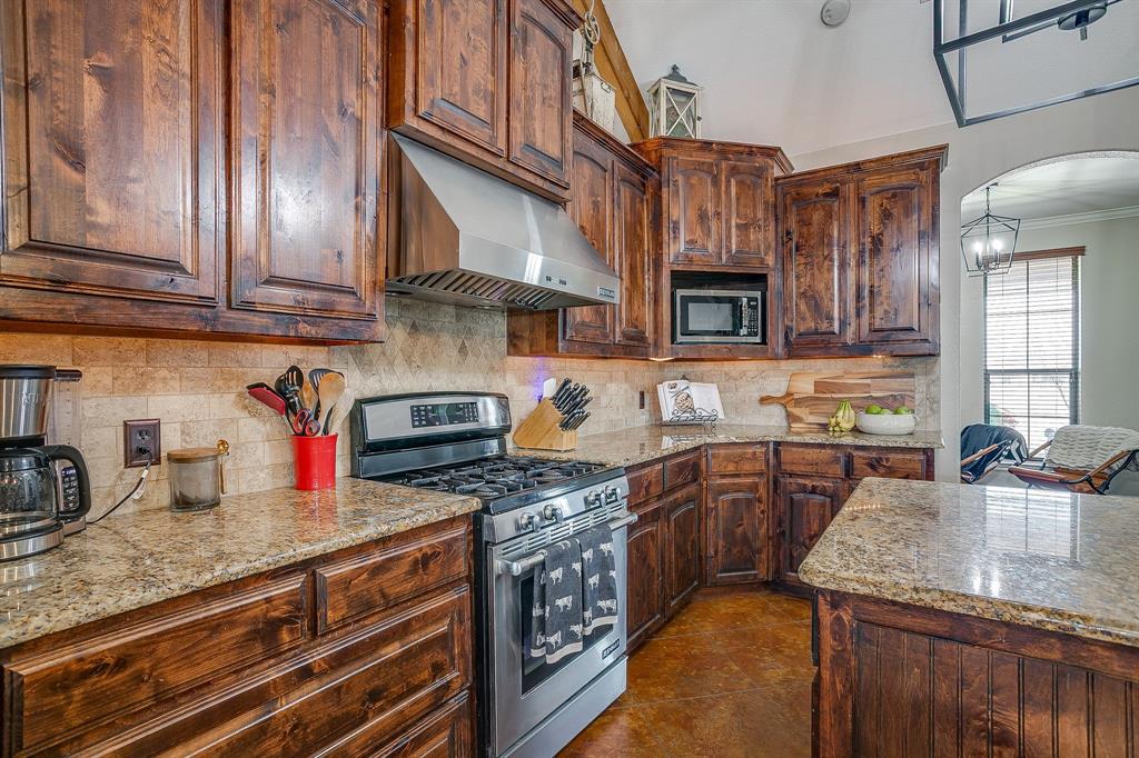 160 Goodnight Trail Rhome, TX 76078 - Photo 11 of 40 a kitchen with stainless steel appliances granite countertop a sink a stove and cabinets